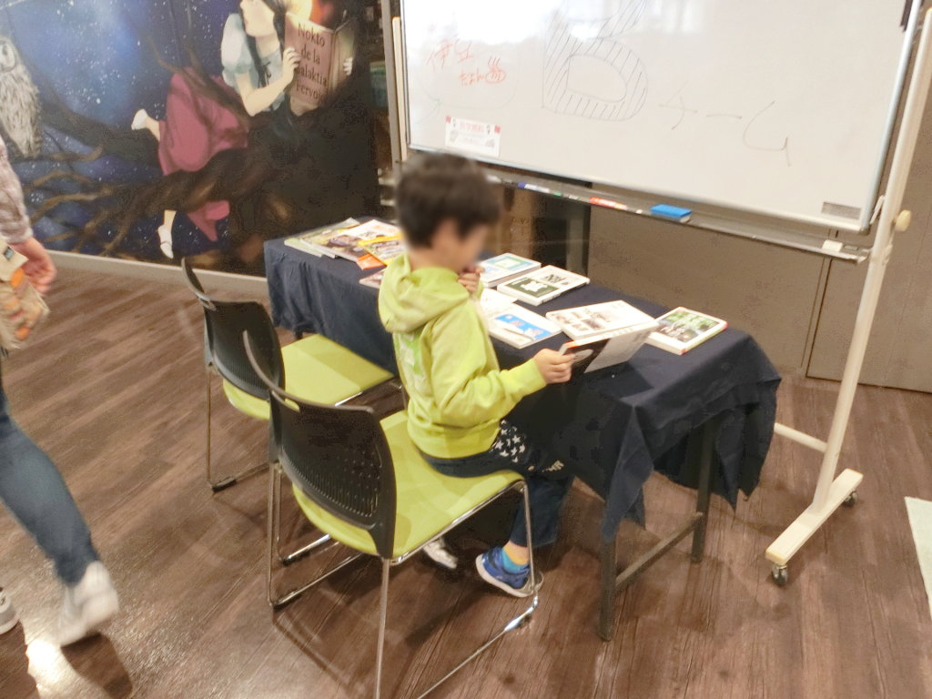 鉄道書籍の新刊紹介コーナーで読みふけるキッズ 鉄道書籍の新刊紹介コーナーで読みふけるキッズ